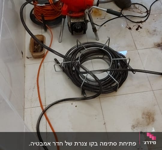 אינסטלטור עם מכונת ניקוי צינורות וכלים נוספים